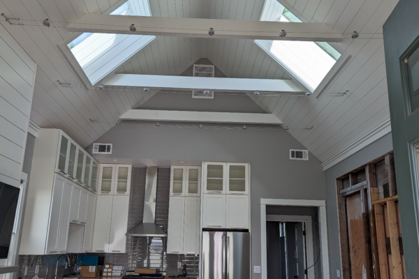 airy-remodel An airy kitchen remodel with high ceilings, white and gray cabinets, state of the art appliances, and custom lighting fixtures.
