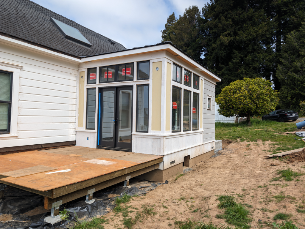The addition of the Shotgun house almost complete with new windows and the base of the deck completed.