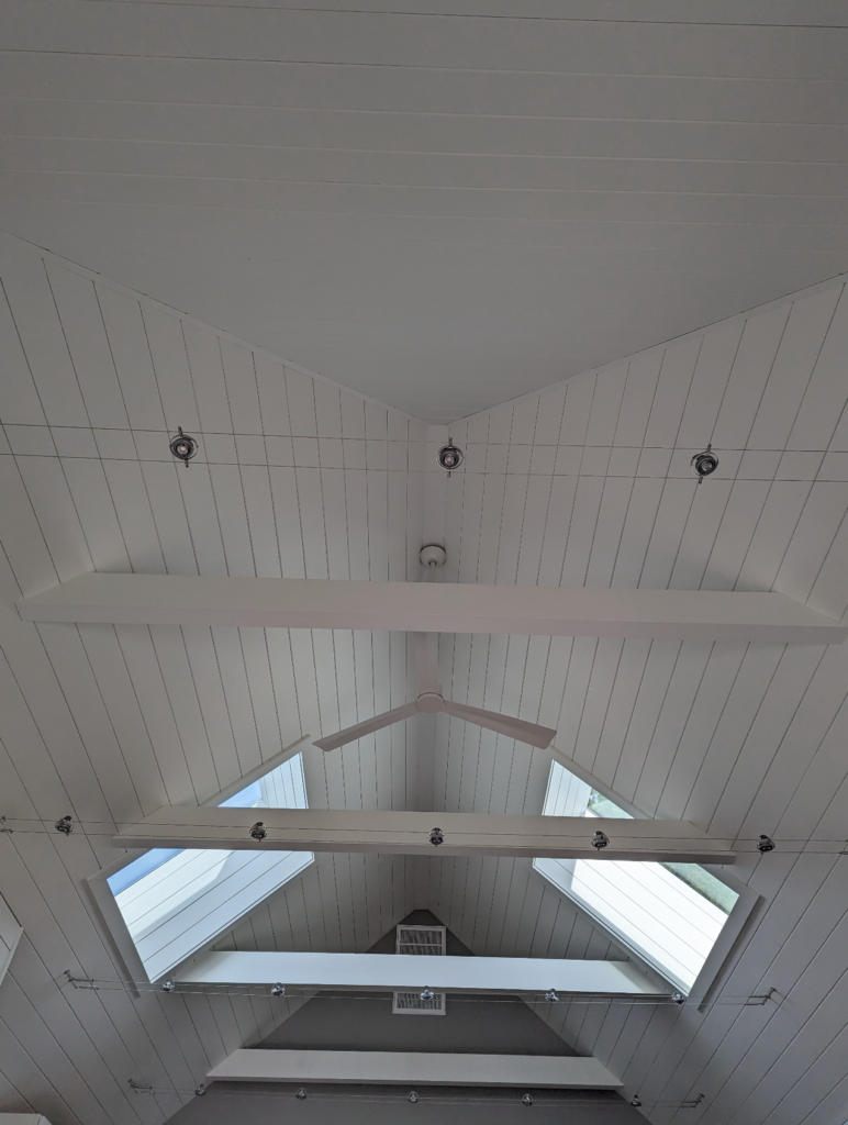 A view of the skylights, roof beams, and unique lighting fixtures in the Shotgun house.