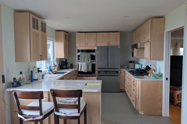 kitchen-after A client's kitchen after their Ultimate Building Solutions remodel showcasing fresh granite countertops, a new high end range, state of the art appliances, light wooden cabinets, and a completely redesigned layout optimizing space for the family.