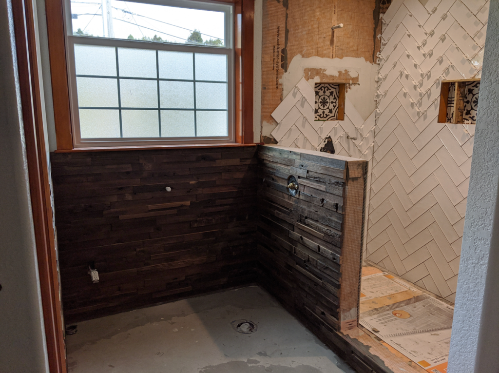 The remodeled Victorian bathroom work in progress, tiling is halfway complete and the plumbing for the bath is prepped.