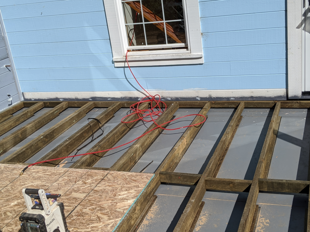 Exterior view of the Victorian Remodel with structural wooden pieces being assembled for the deck.